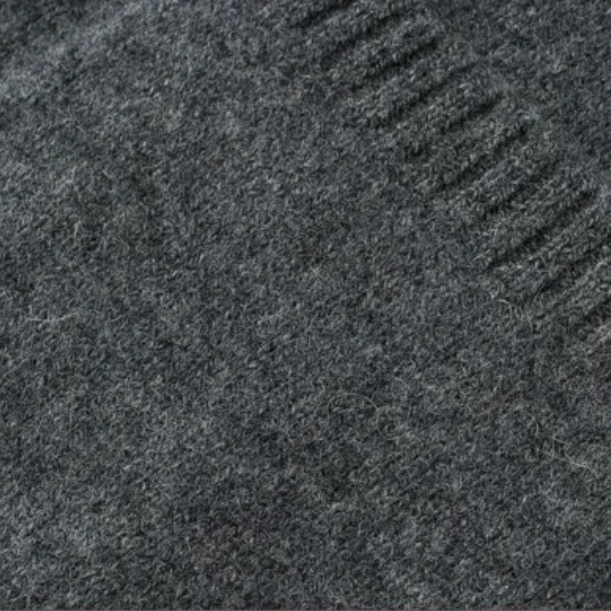 Close-up of heather dark gray knit fabric texture for a cardigan