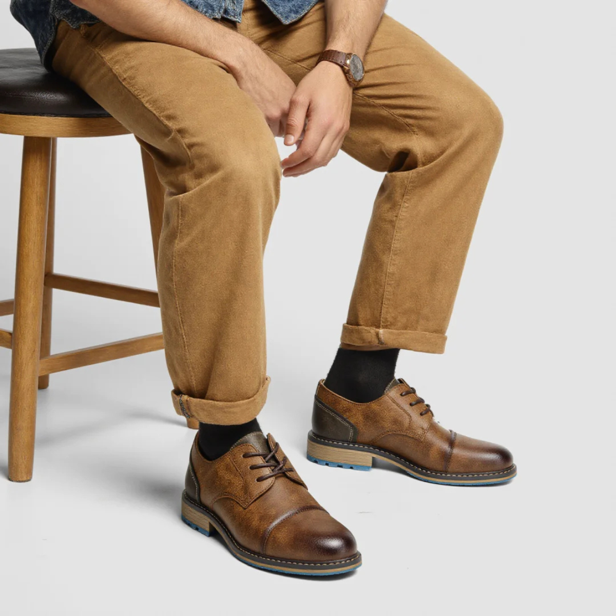 Men's brown retro lace-up leather oxford shoes with blue sole, worn with pants