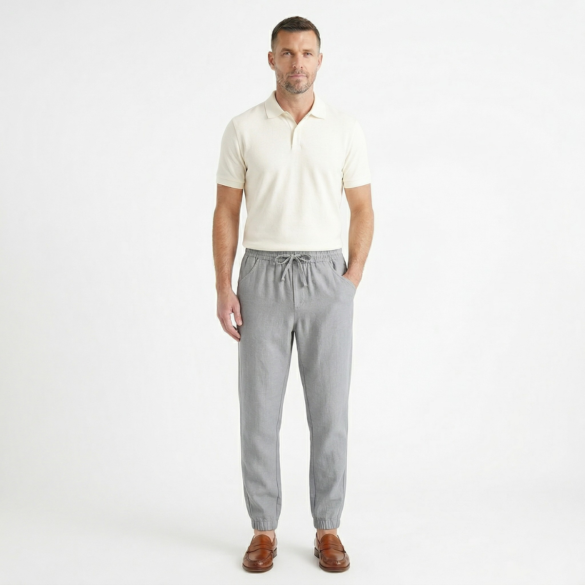 Gray cotton jogger pants on model with elastic waist, drawstring, and tapered cuffs