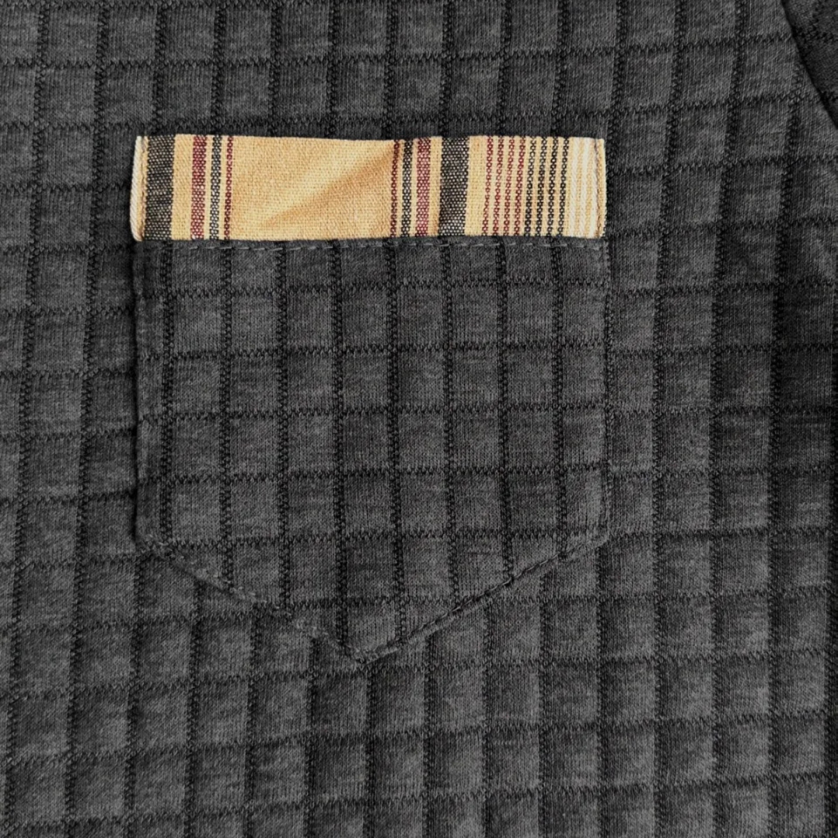 Dark waffle-knit fabric texture with subtle grid pattern