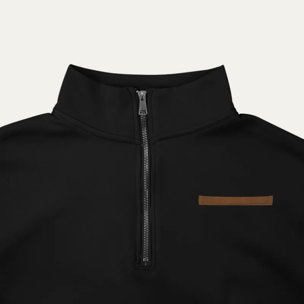 Black half-zip stand-collar sweater close-up of zipper and chest trim patch
