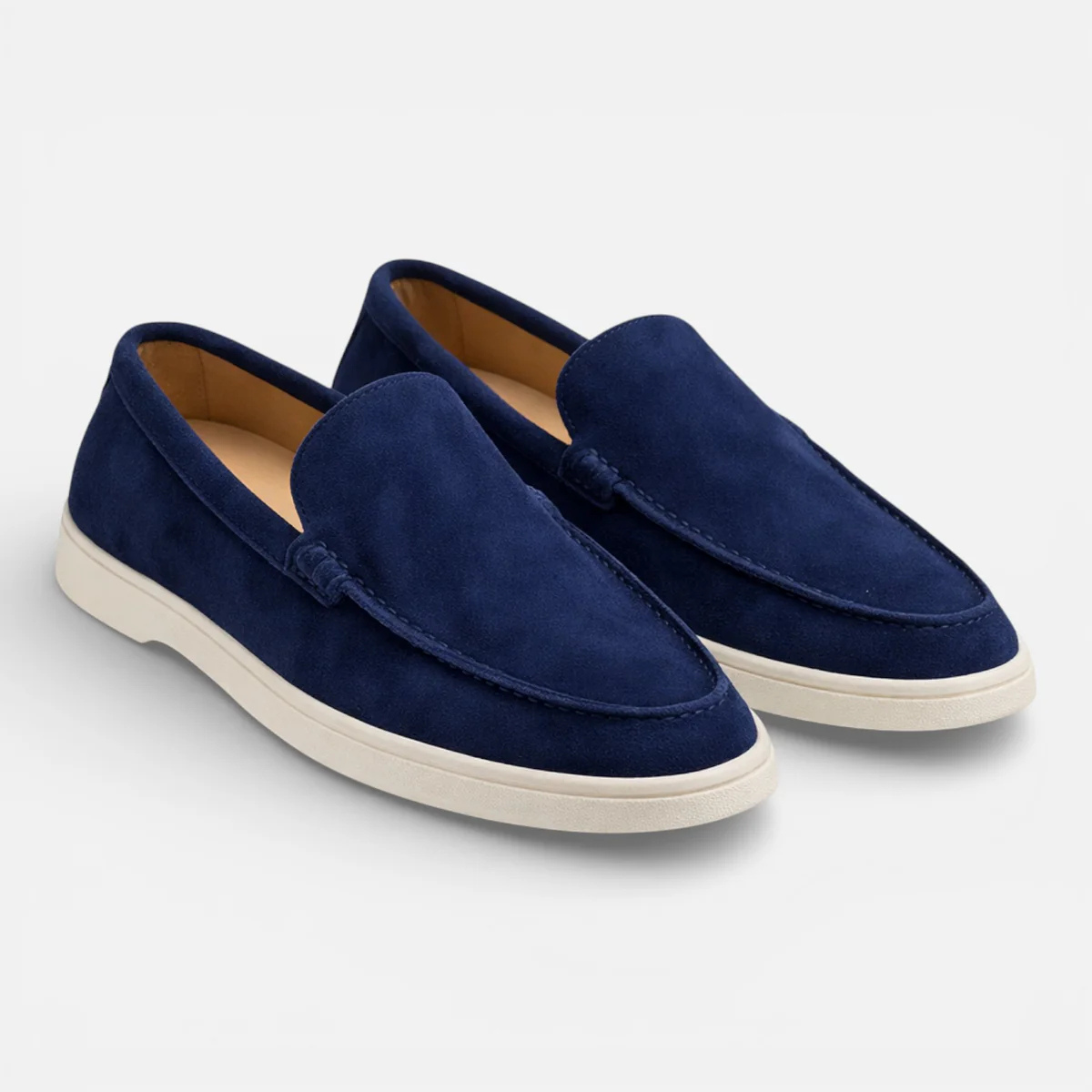 Navy suede slip-on loafers with moccasin stitching and low white rubber sole