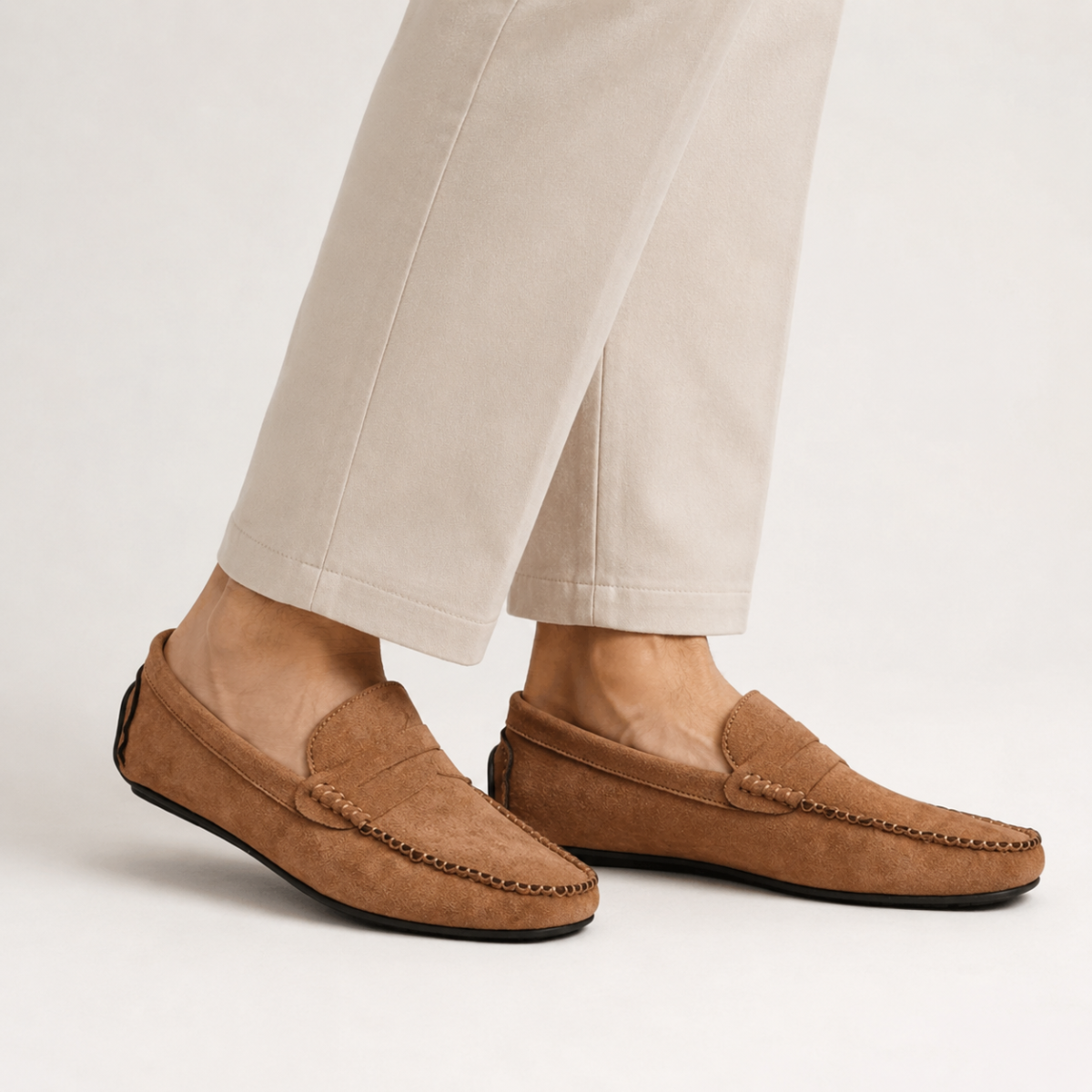 Brown suede moccasin loafers, slip-on style with stitched moc seams and braided detail.