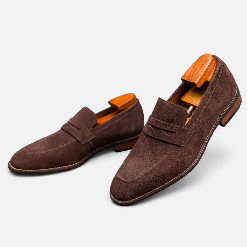 Men's brown suede slip-on penny loafers with side penny strap and low block heel.