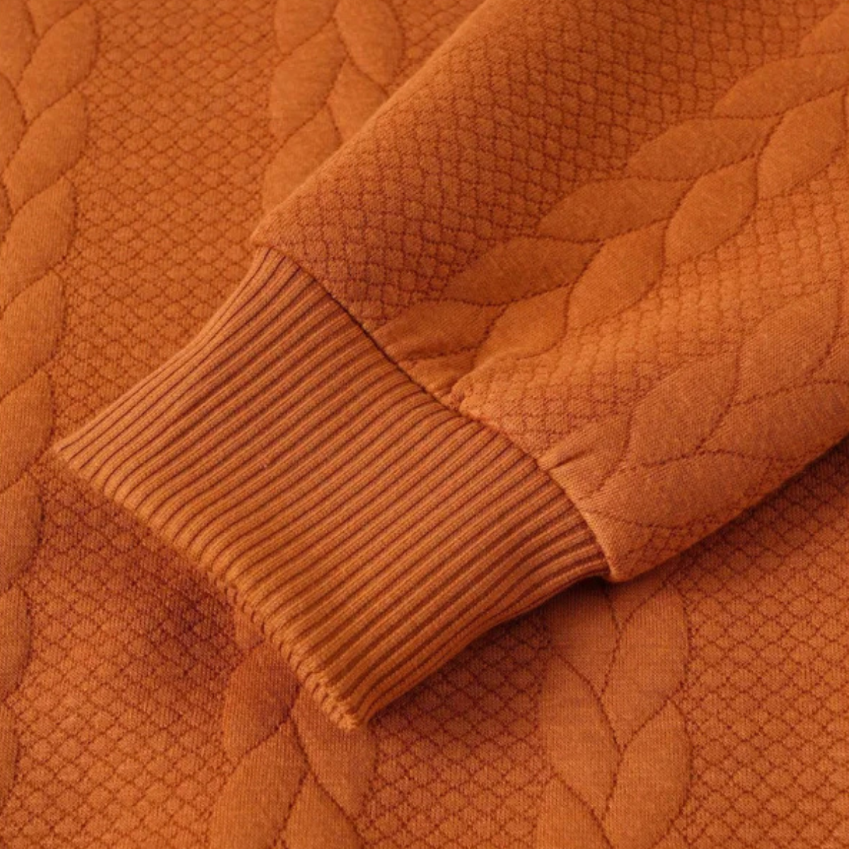 Men's cable knit turtleneck sleeve detail, rust orange ribbing