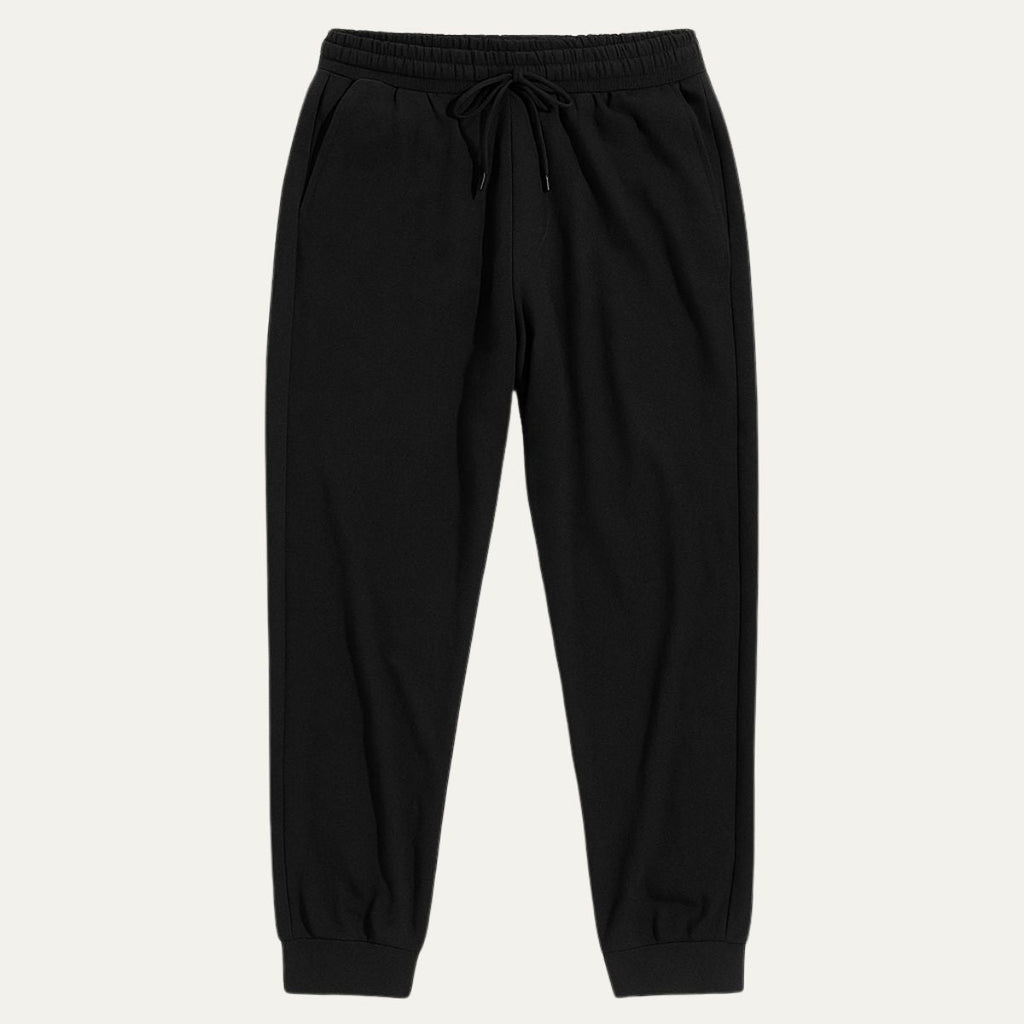Black cotton jogger pants with elastic waistband, drawstring, and tapered ankle cuffs