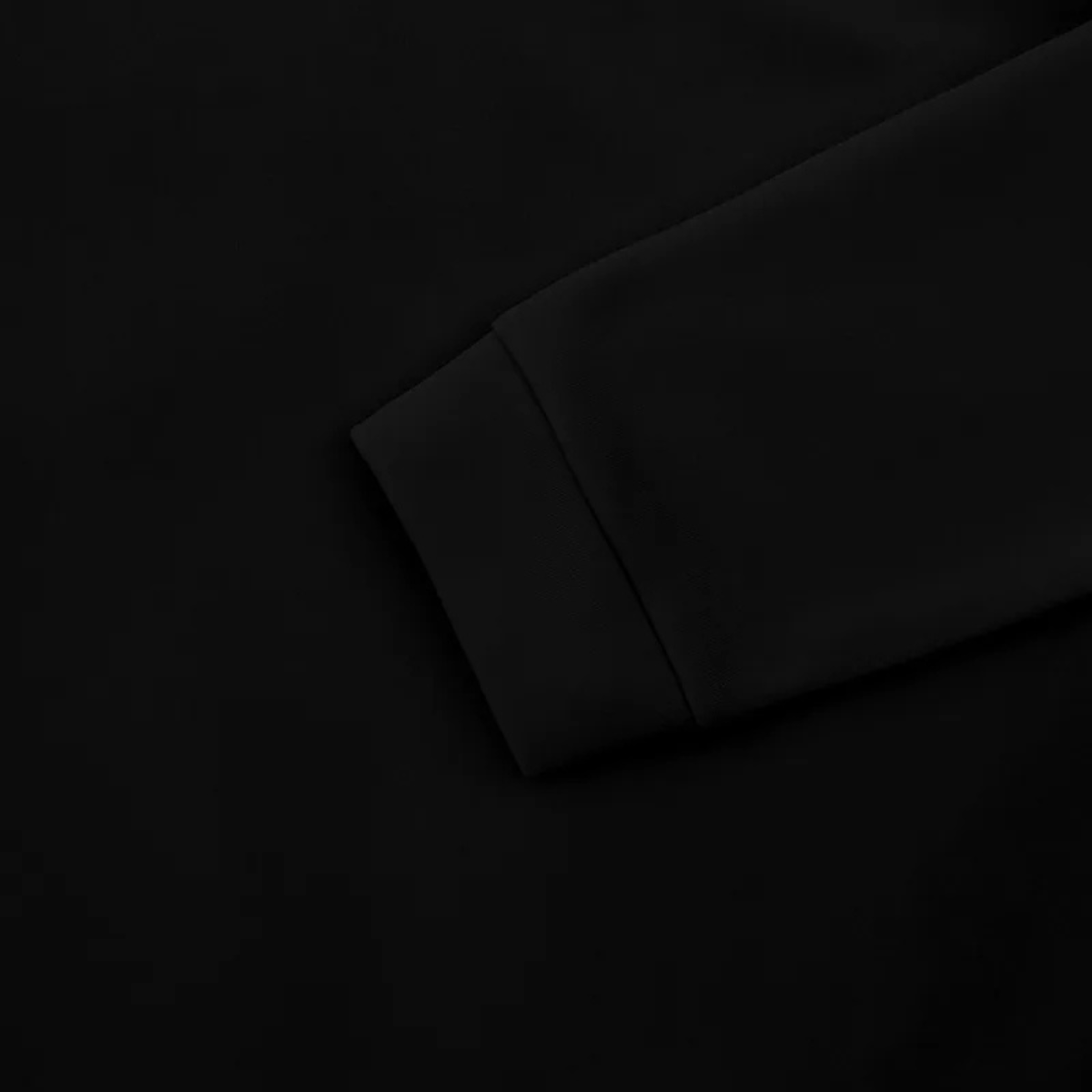 Black sweater fabric close-up with seam detail at sleeve cuff