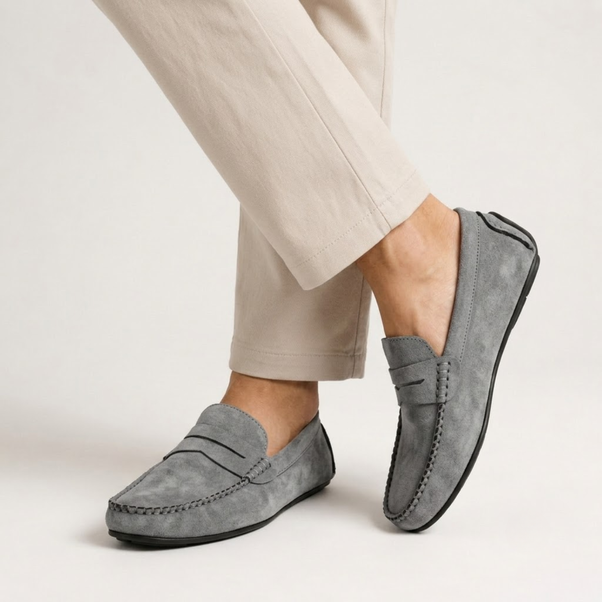 Gray suede moccasin loafers, slip-on design with stitched vamp and moc seam stitching.