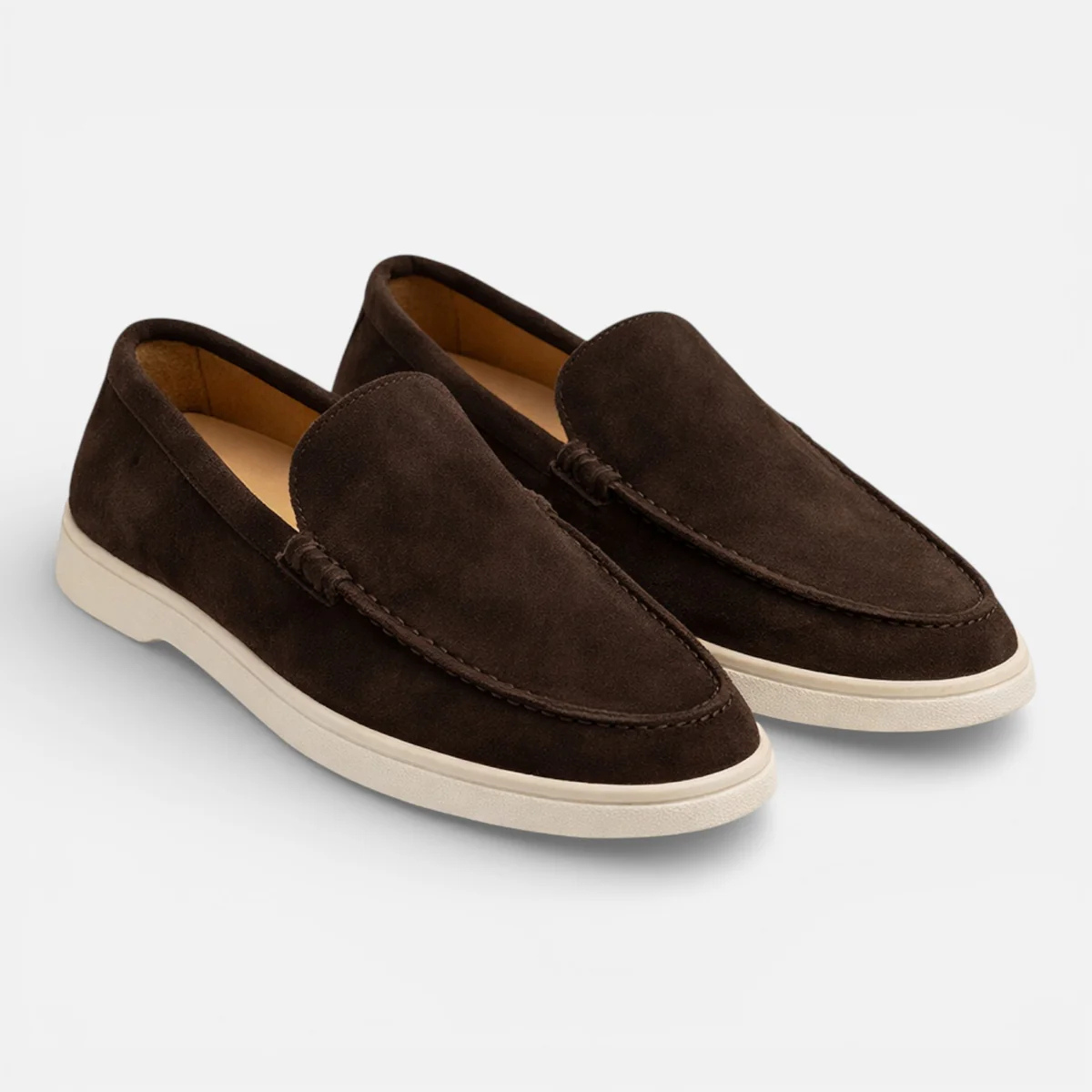 Brown suede slip-on loafers with moccasin stitching and low white rubber sole