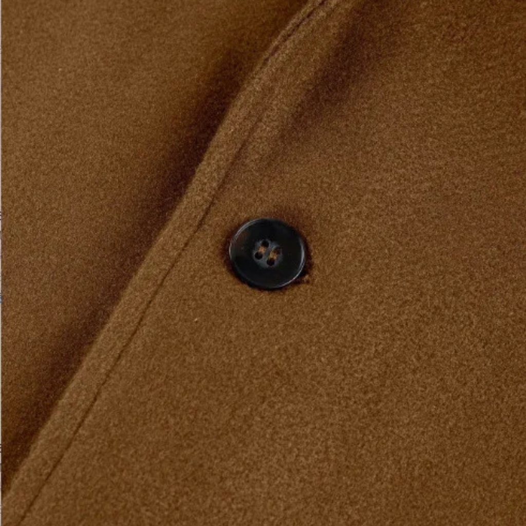 Men’s overcoat close-up of a dark button on the front placket