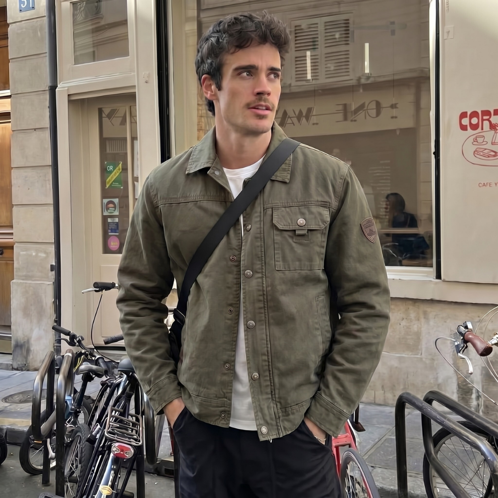 Olive men’s utility jacket worn with white shirt; chest flap pocket and angled utility pocket