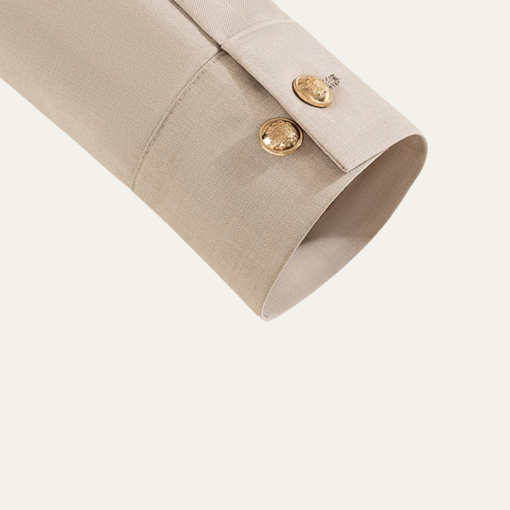 Beige suit jacket sleeve cuff with stitched seam and gold-tone button
