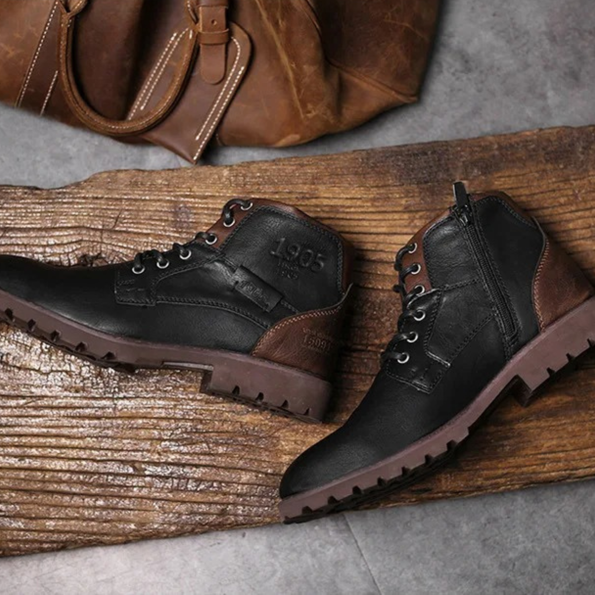 Pair of combat boots: brown lace-up and black side-zip boots on wooden plank