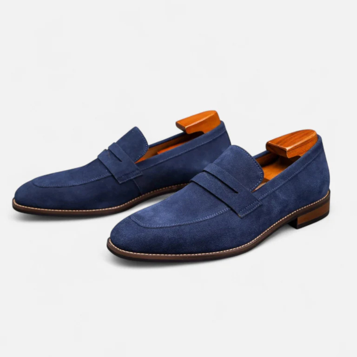 Men's blue suede slip-on penny loafers with side penny strap and low block heel.