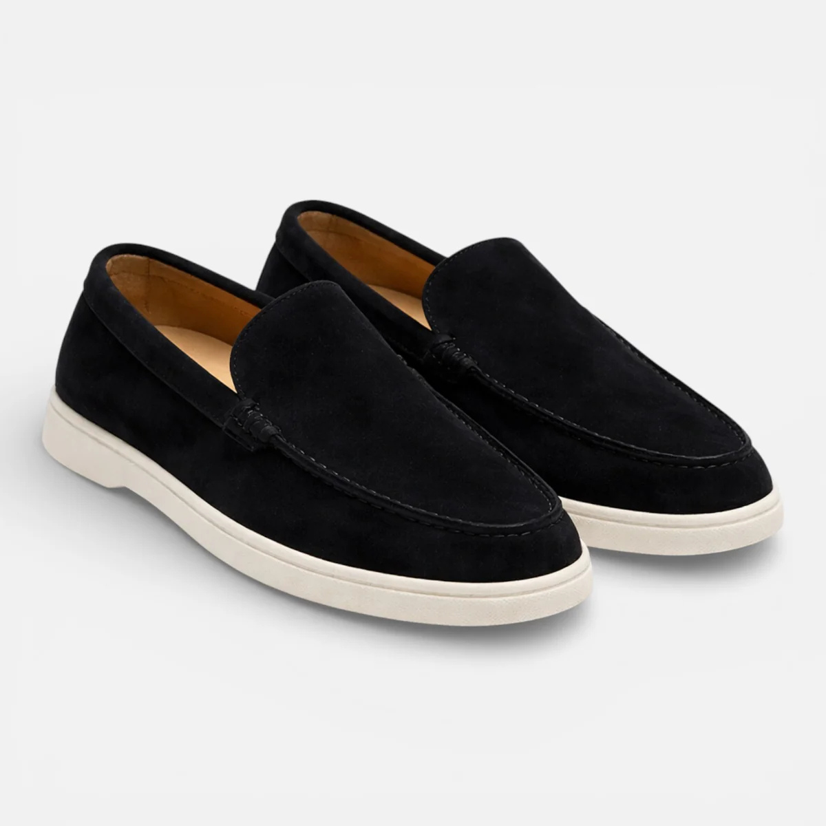 Black suede slip-on loafers with moccasin stitching and low white rubber sole