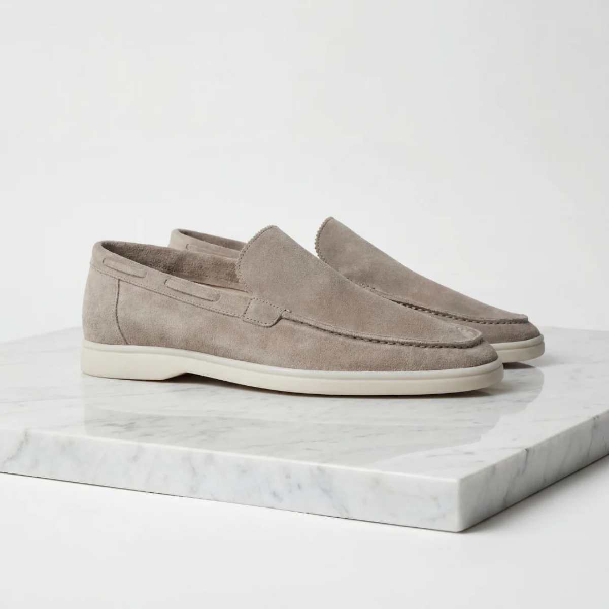 Men's beige suede moc-style slip-on loafers with stitched vamp and white rubber sole