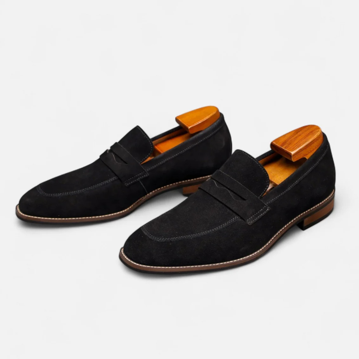 Men's black suede slip-on penny loafers with side penny strap and low block heel.