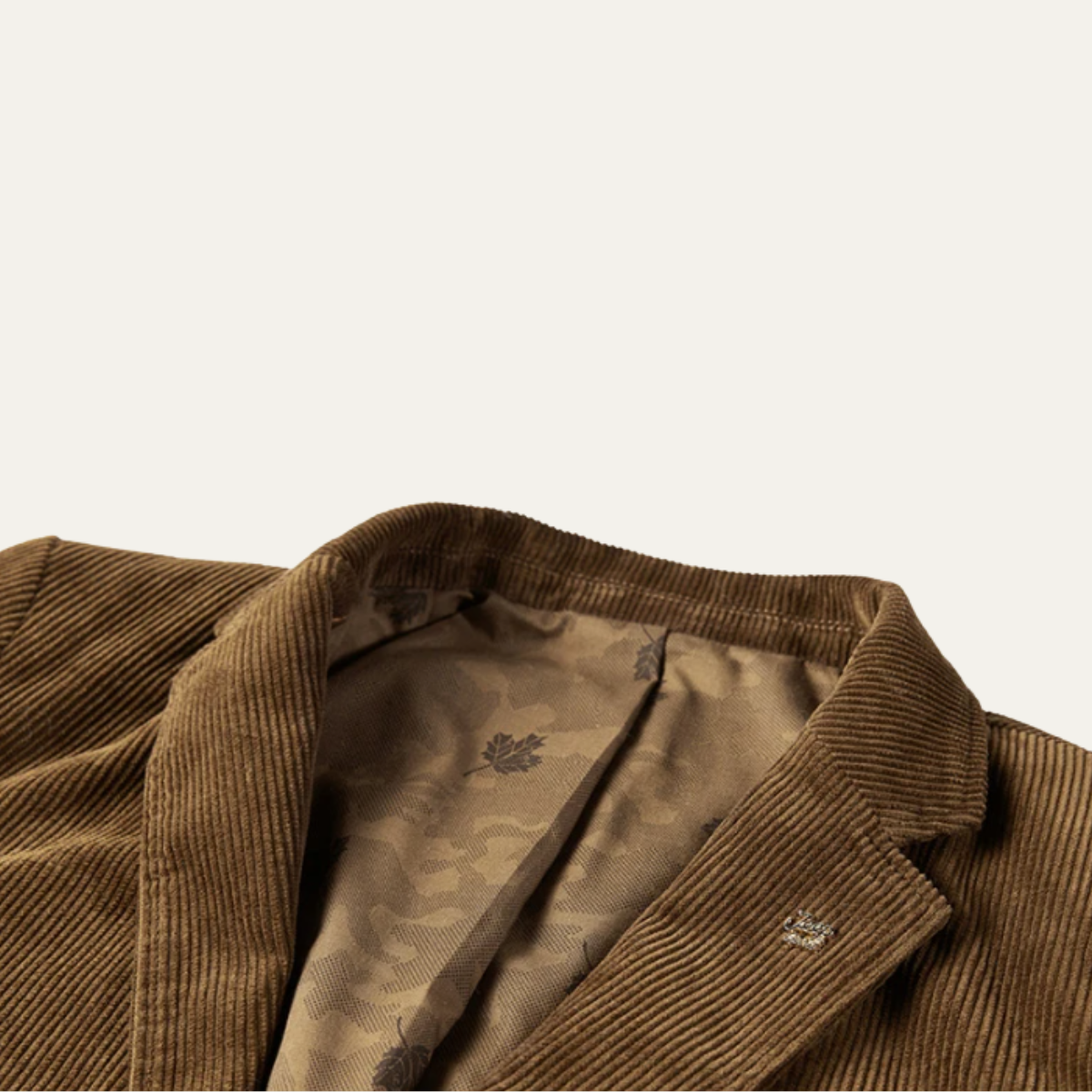 Brown corduroy collar and inner lining detail with patterned fabric and top button tab.