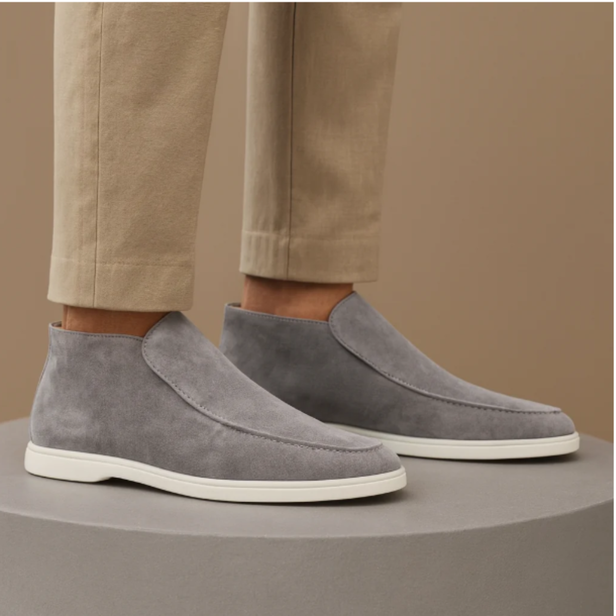 Men's gray suede slip-on loafers with moc-stitch seam and white rubber sole.