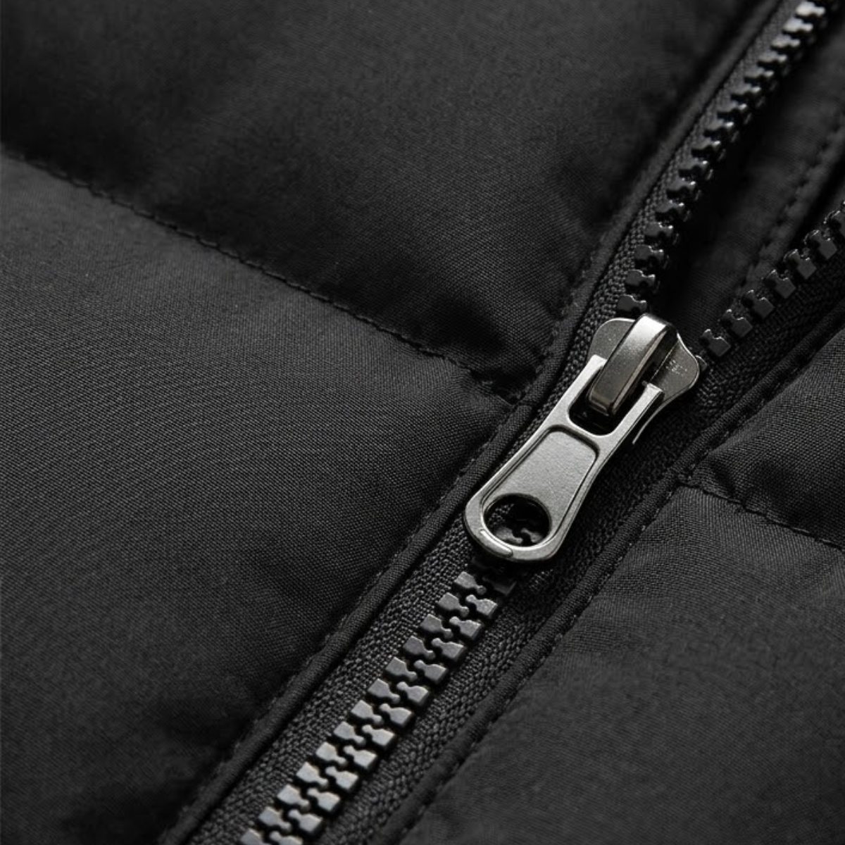 Black padded puffer vest close-up of metal zipper pull and stitching
