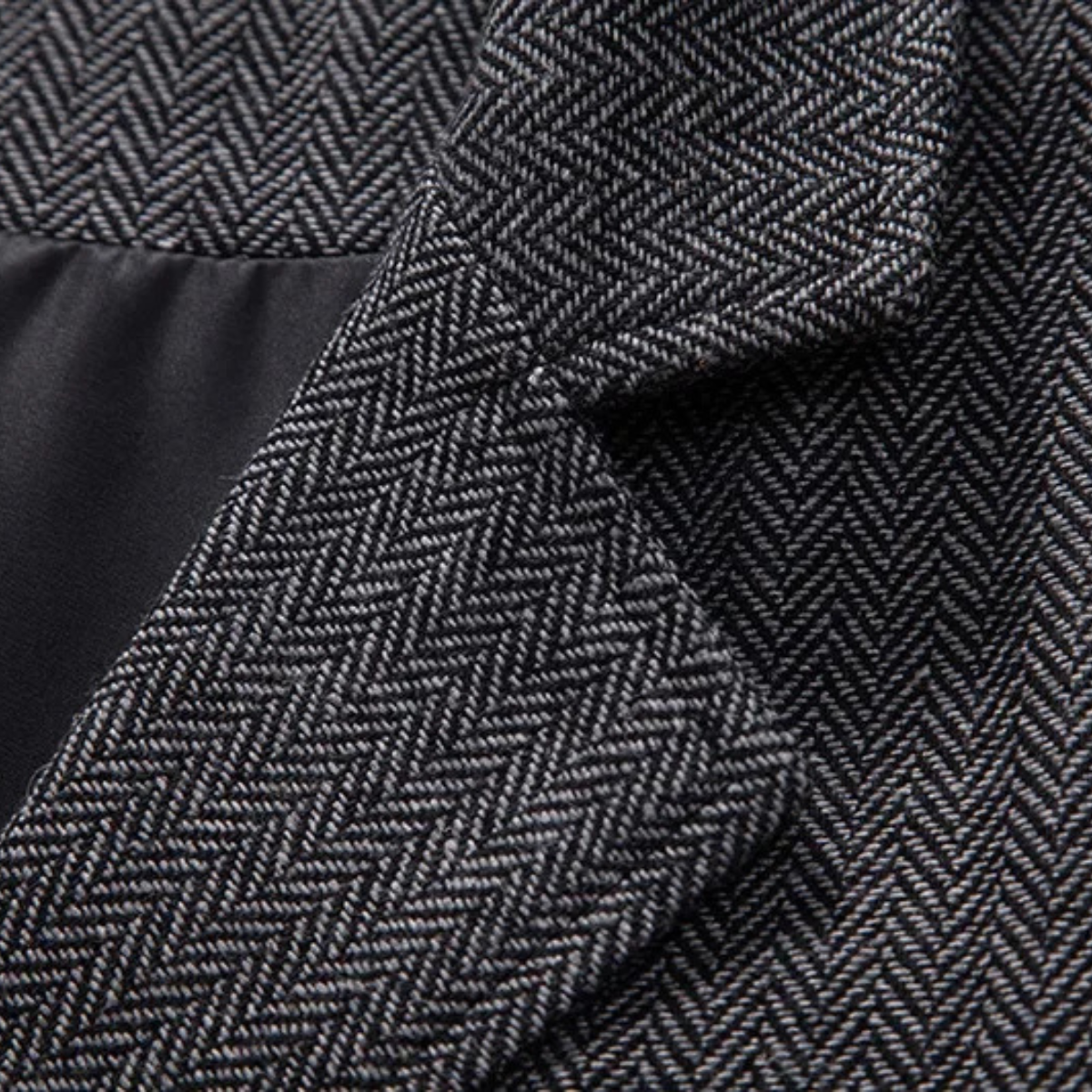 Dark gray tweed fabric close-up with herringbone texture detail