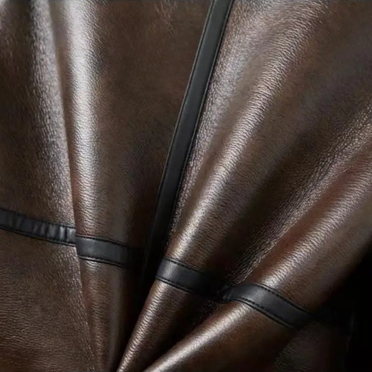 Brown leather jacket close-up of diagonal panels with black trim