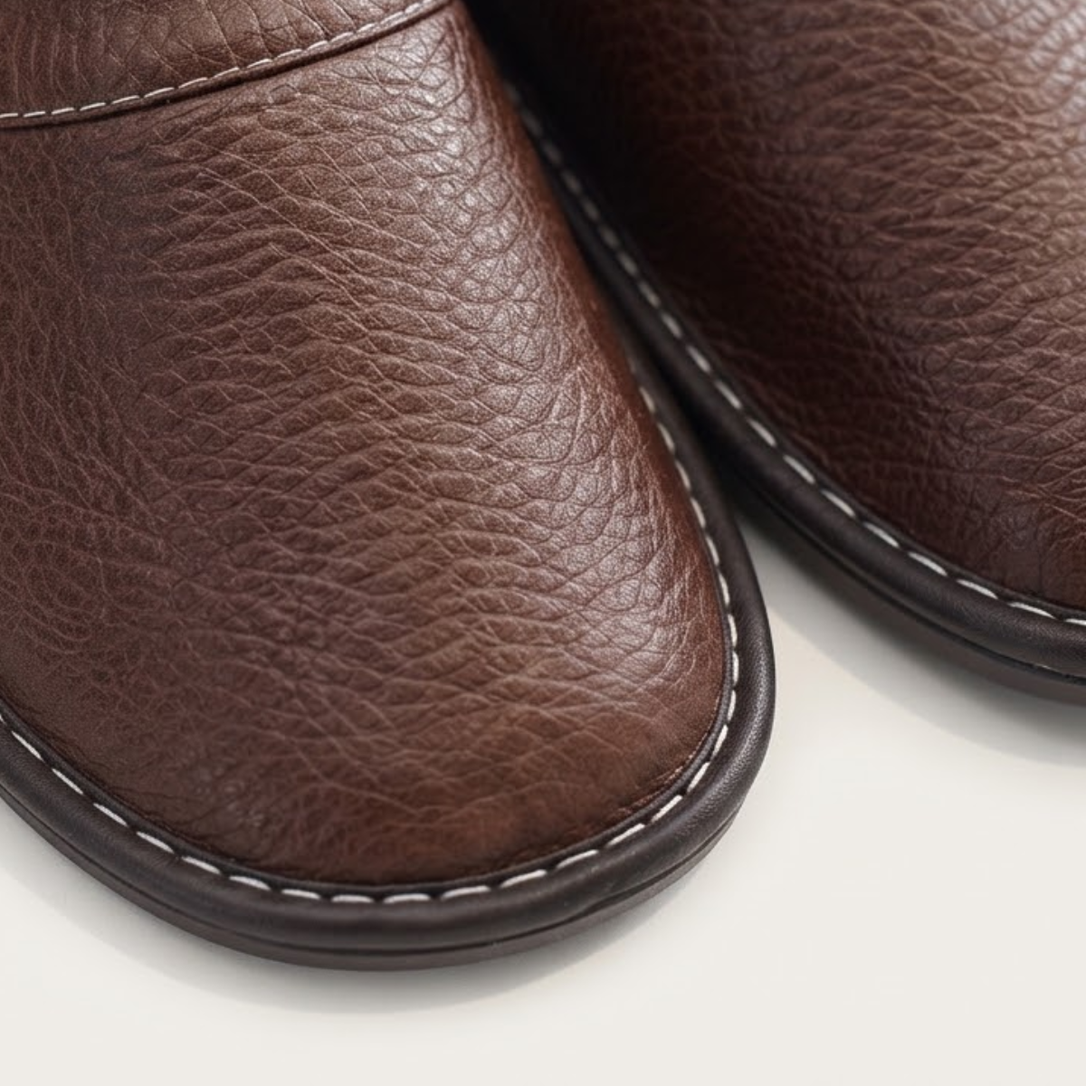 Close-up of brown leather slip-on clog toe with contrast stitched edge trim