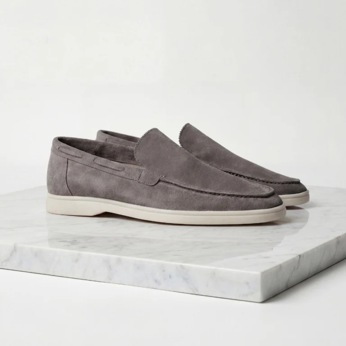 Men's gray suede slip-on loafer with moc-style stitching and low white sole