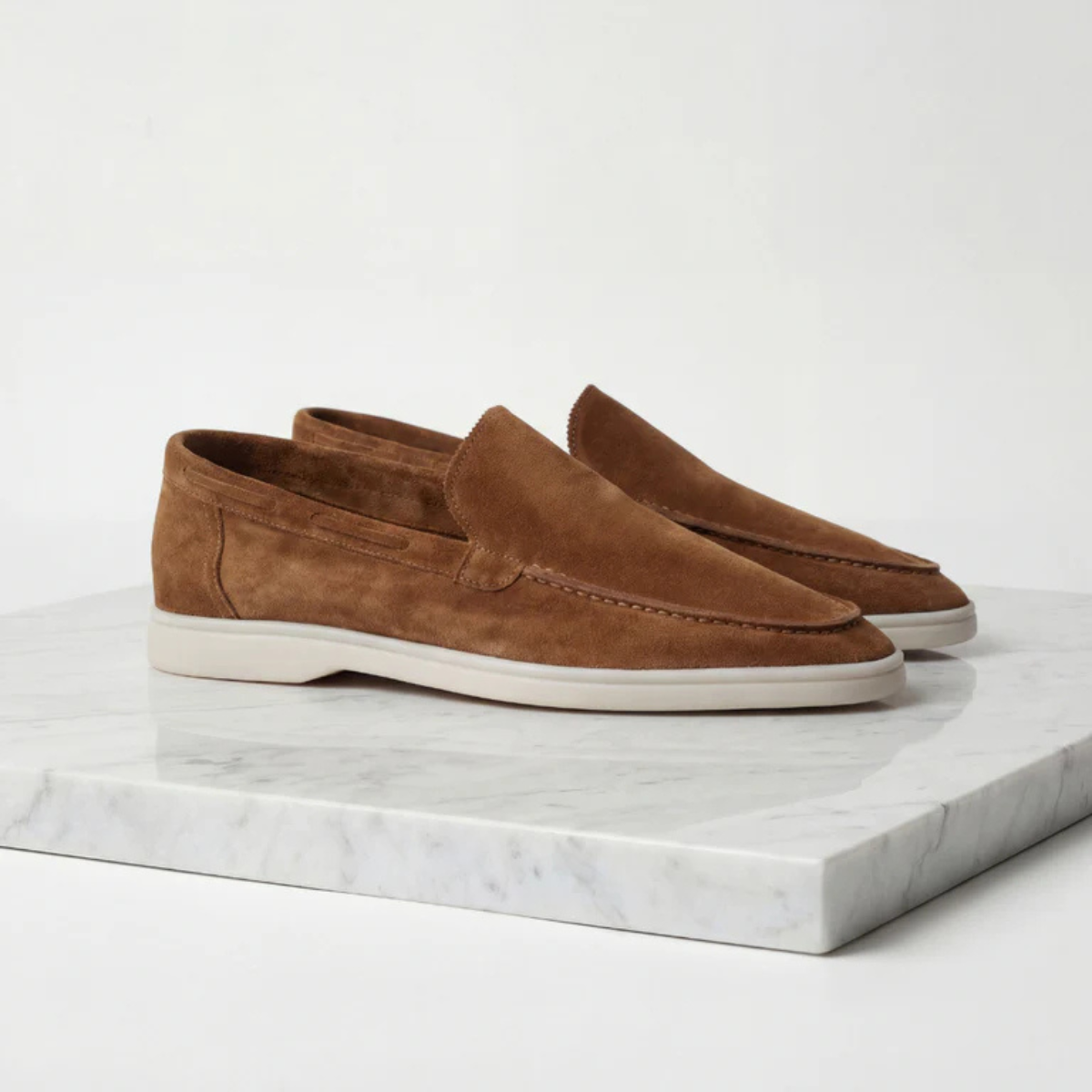 Men's brown suede slip-on loafer with moc-style stitching and white rubber sole