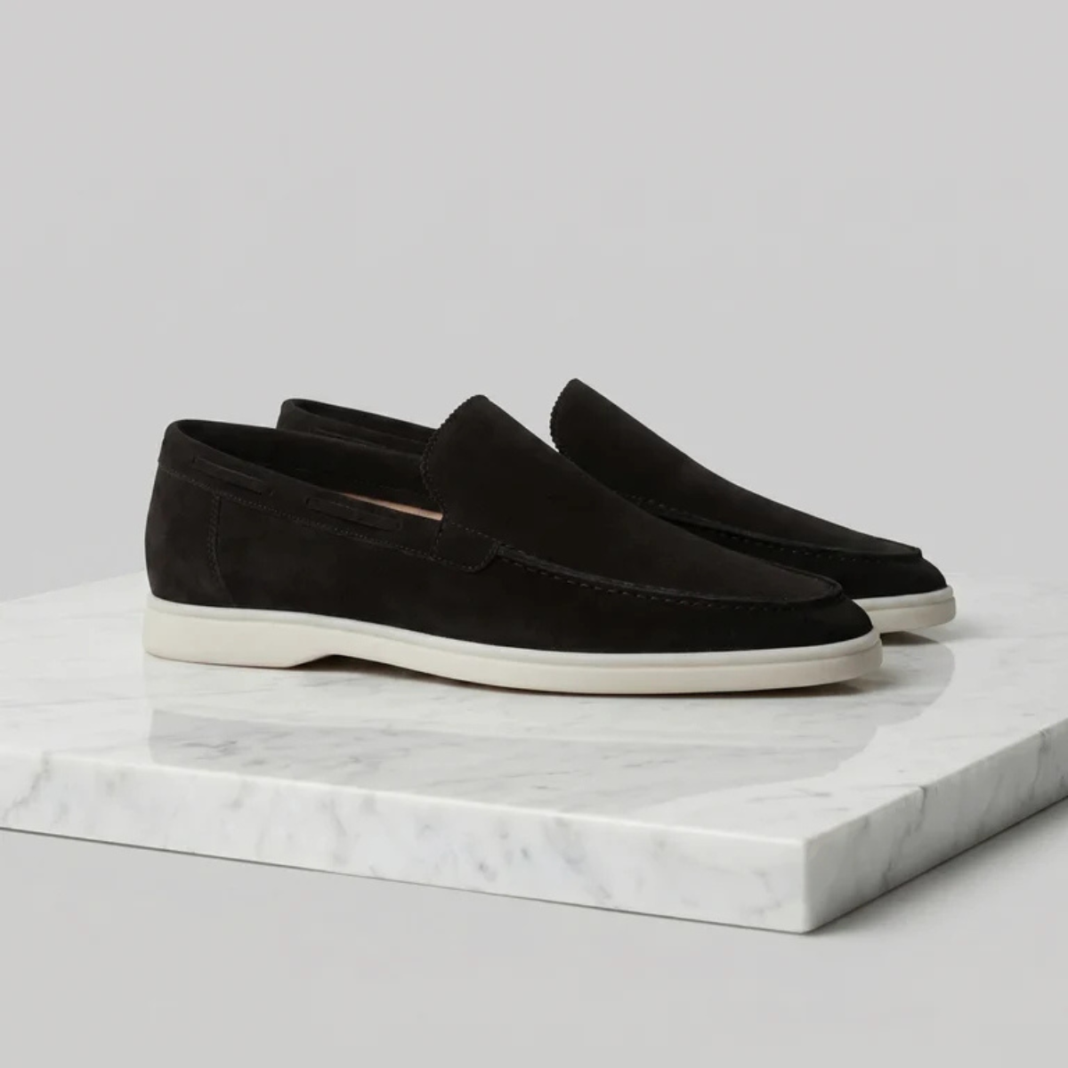 Men's black suede slip-on loafer with moc-style stitching and low white sole