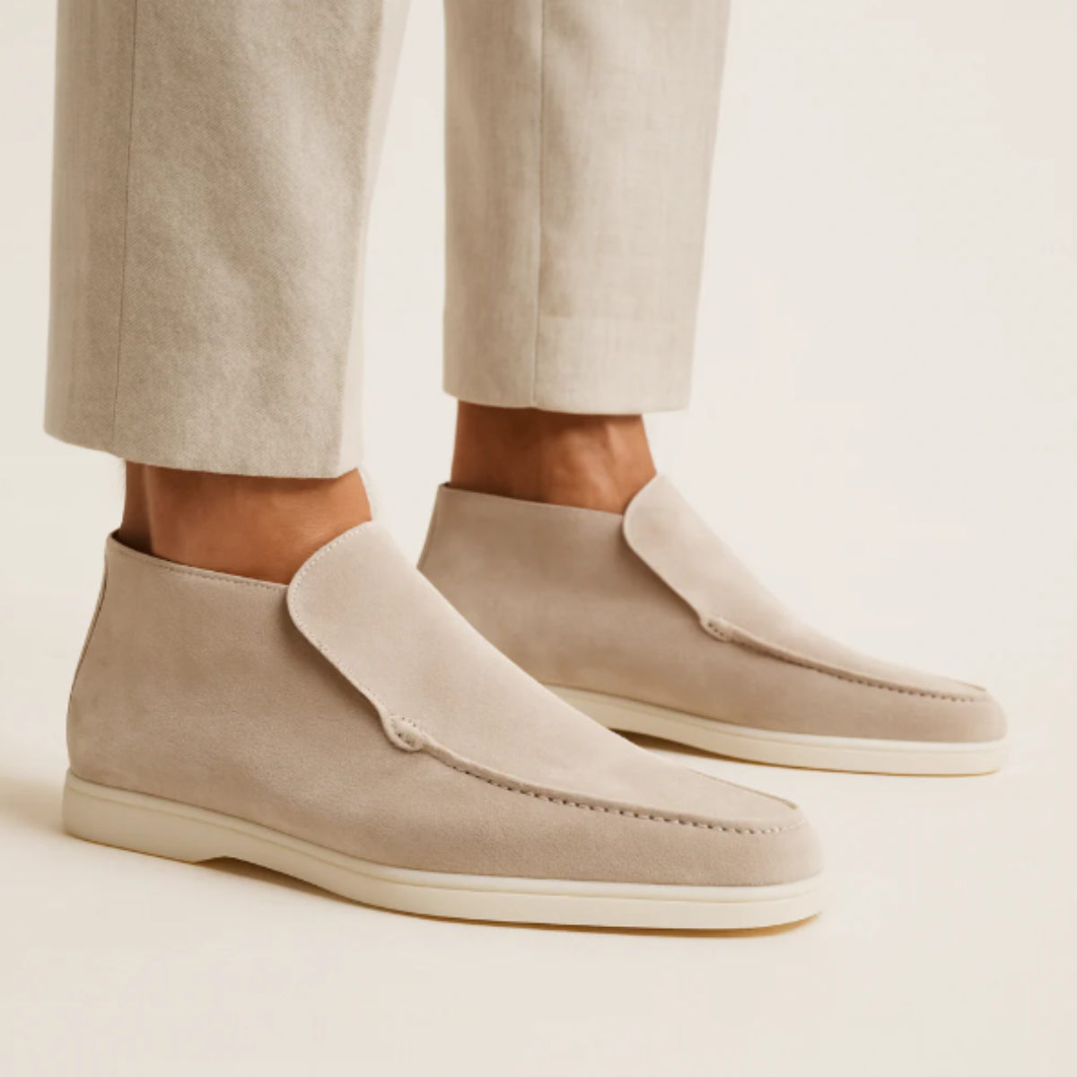 Men's beige suede slip-on loafers with moc-stitch seam and white rubber sole.