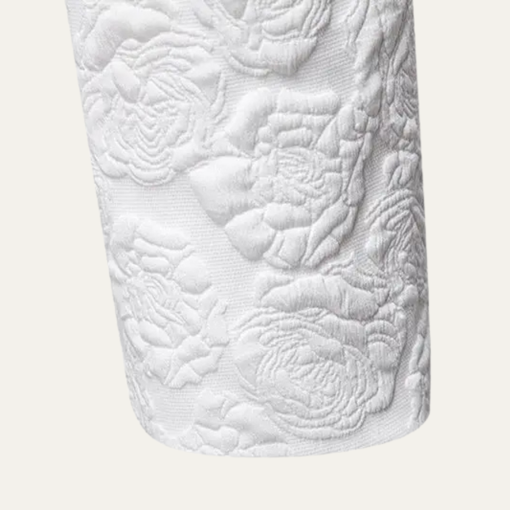 White textured blazer sleeve detail with embossed floral-style pattern