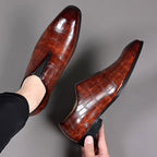 Pair of glossy brown croc-texture loafers with slip-on profile and low block heels