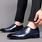 Blue croc-texture loafer on foot with low block heel and slip-on fit