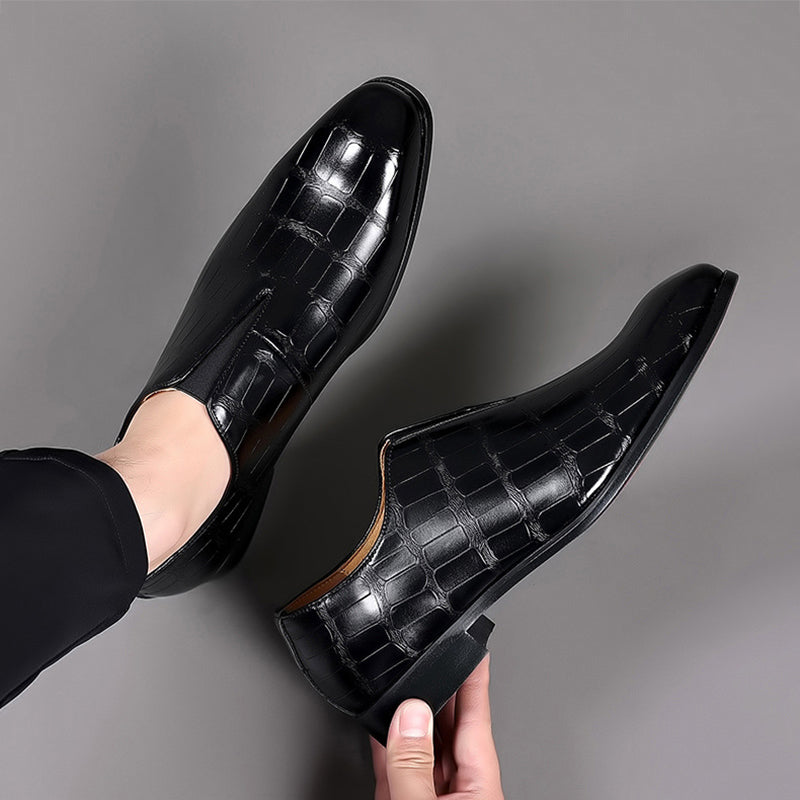 Pair of glossy black croc-texture loafers with slip-on profile and low block heels