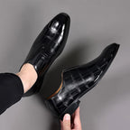 Pair of glossy black croc-texture loafers with slip-on profile and low block heels