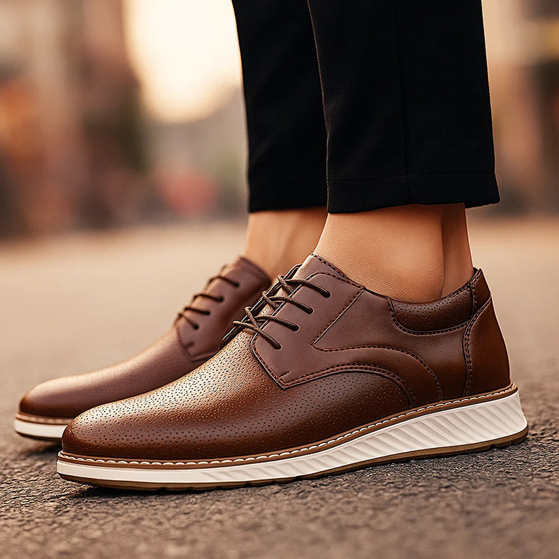 Brown lace-up oxford shoes with perforated finish and white sole worn outdoors