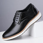 Black lace-up oxford shoes with perforated finish and white sole, side view