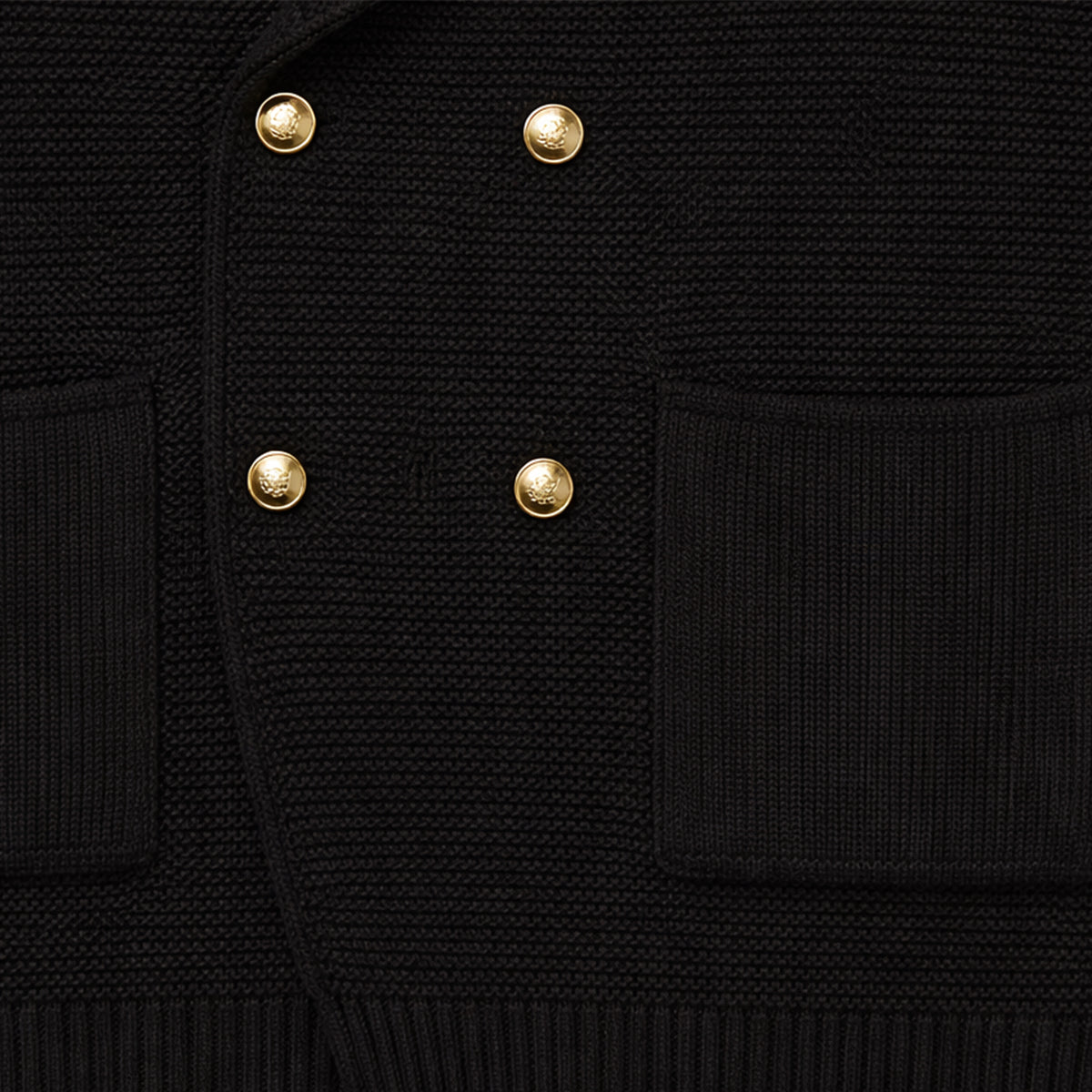 Men's black knit cardigan detail: gold double-breasted buttons and patch pockets