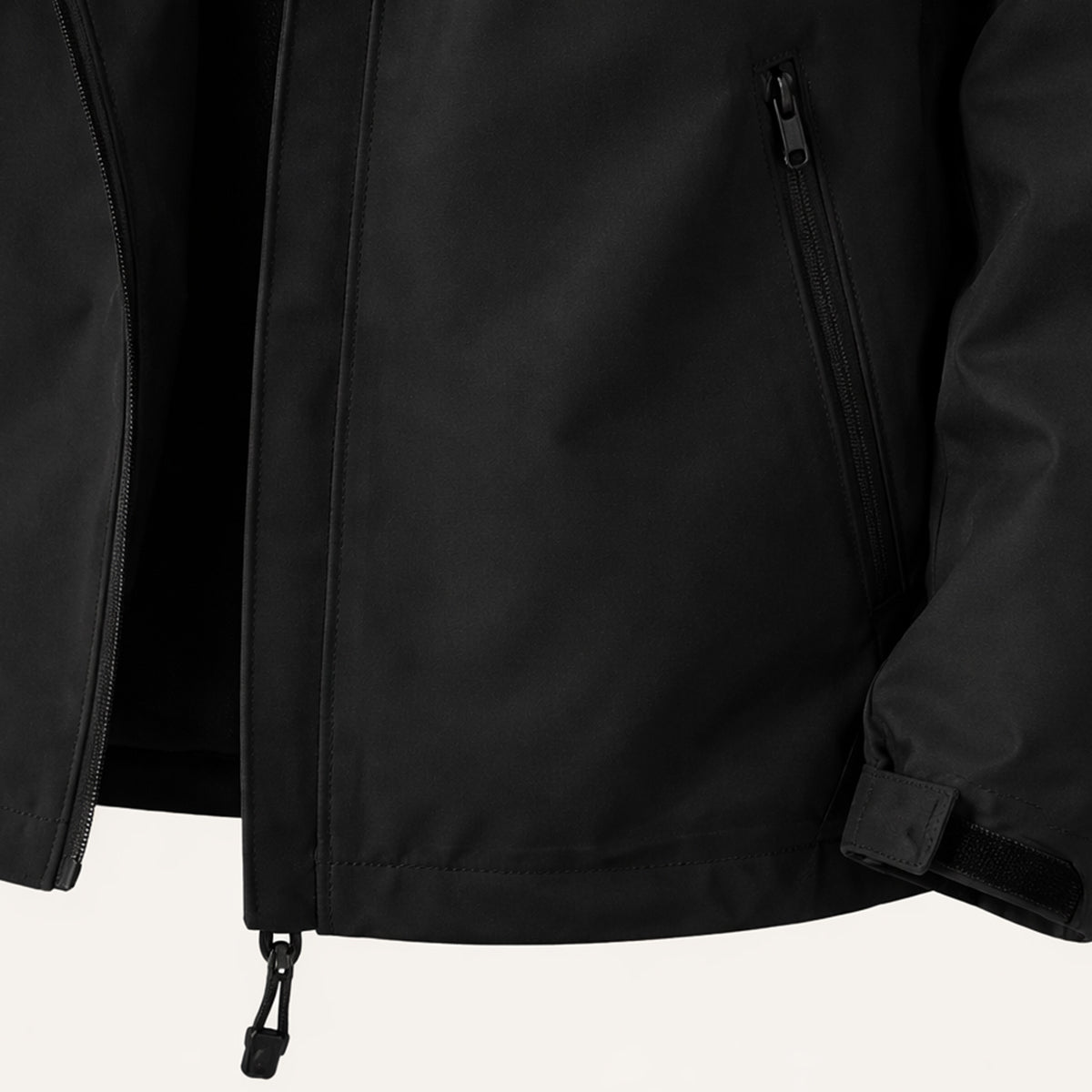 Black rain jacket detail with front zip, pockets, and adjustable cuff tabs