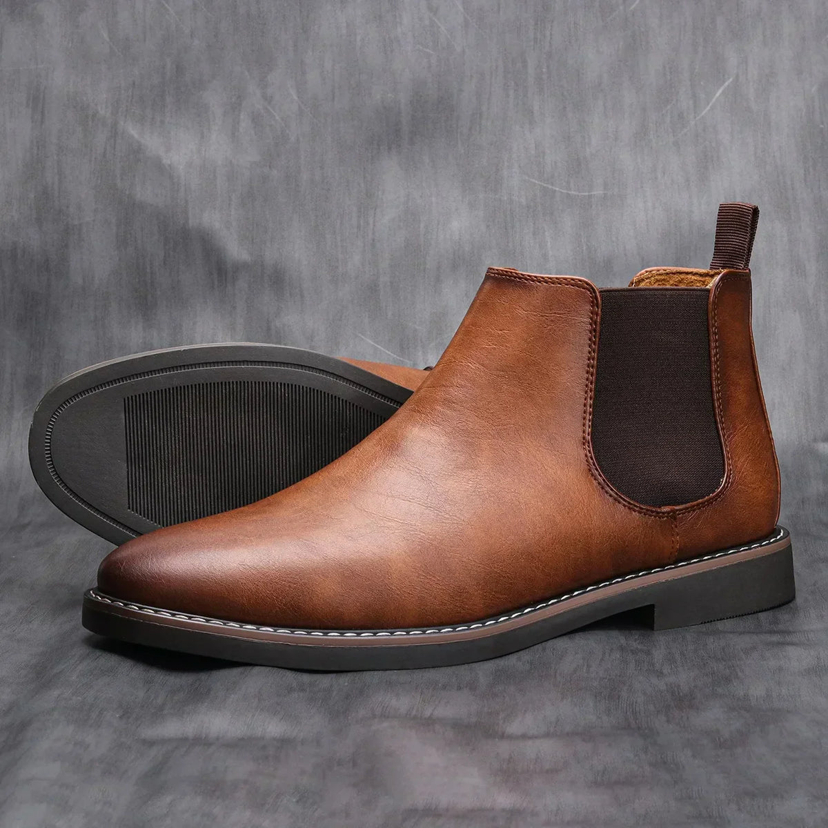 Brown leather chelsea boots with elastic gore and textured rubber outsole, side view.