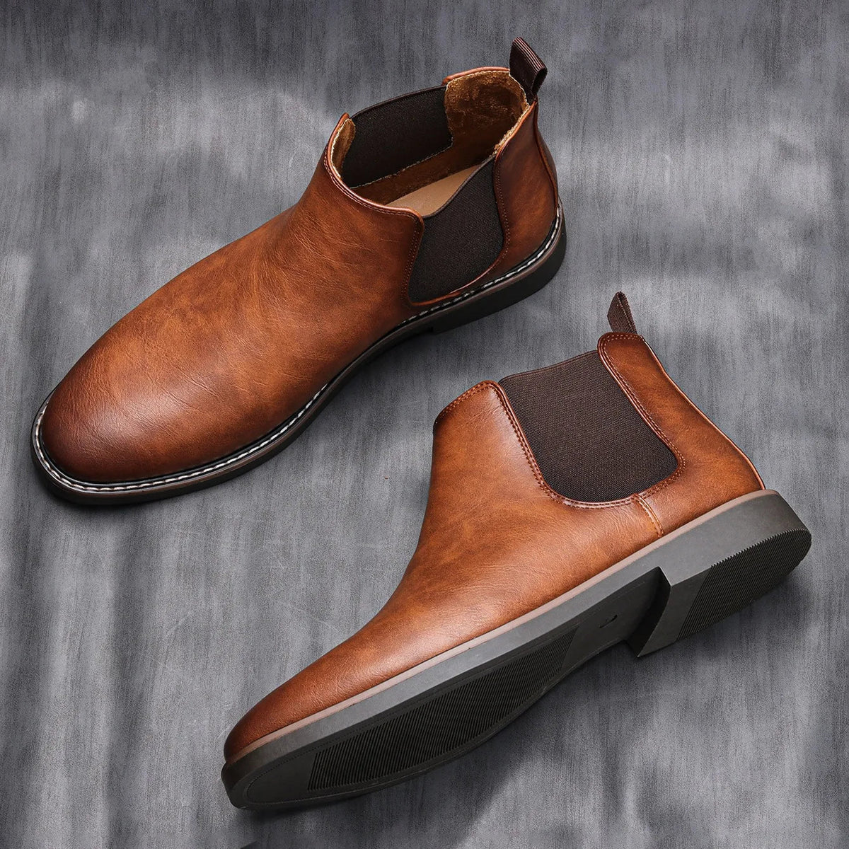 Cognac leather chelsea boots with elastic side panels and padded collar, two views.
