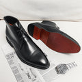 Gloss black leather ankle dress boots, lace-up with pointed toe and low heel.