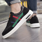 Black genuine leather retro sneakers on foot with multicolor side stripe