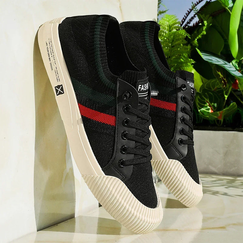 Black lace-up sneakers with mesh upper, green/red stripe accents and white sole