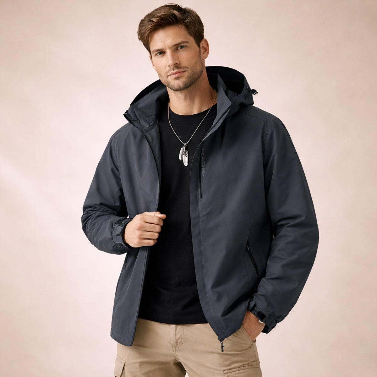 Dark gray hooded rain jacket on model with front zipper