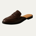 Brown leather loafer mule with strap, embossed finish, and dark rubber sole.