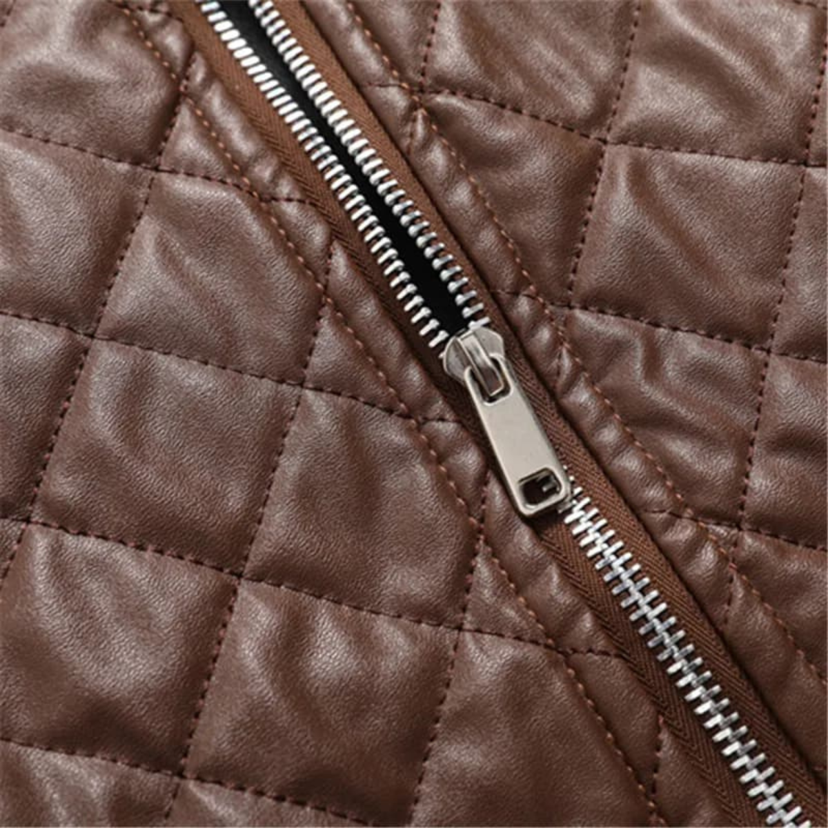 Close-up of brown quilted leather bomber jacket zipper with metal slider and teeth