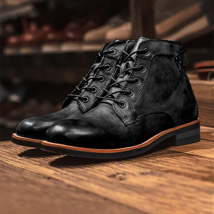 Close-up of men's black lace-up ankle boots with metal eyelets and stitched panels
