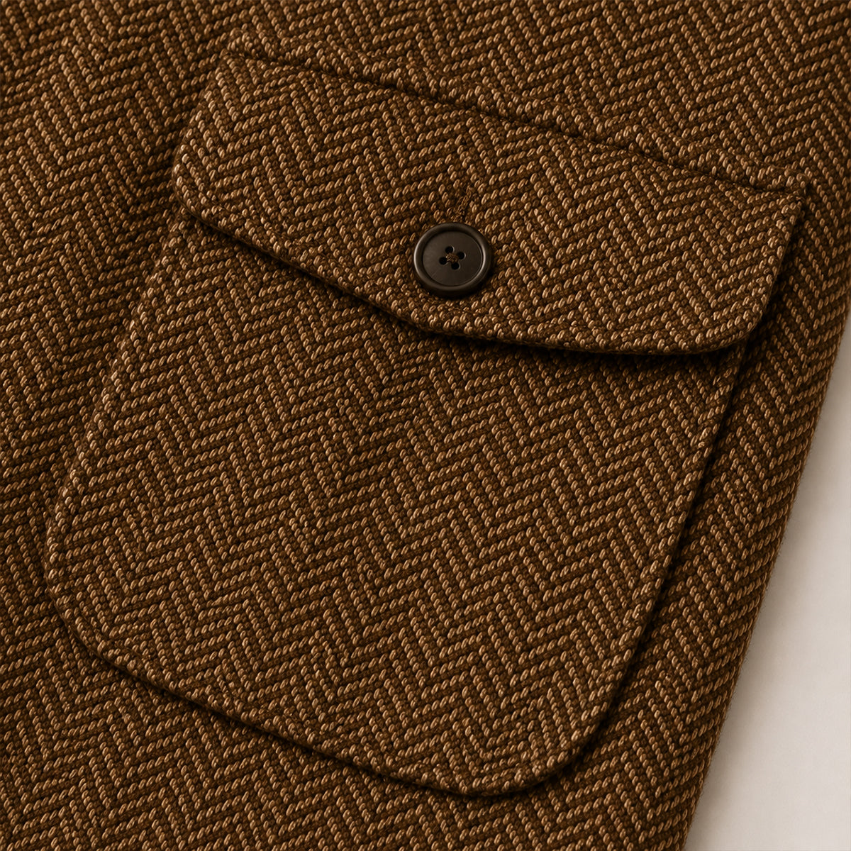 Dark brown tweed blazer pocket flap detail with dark button